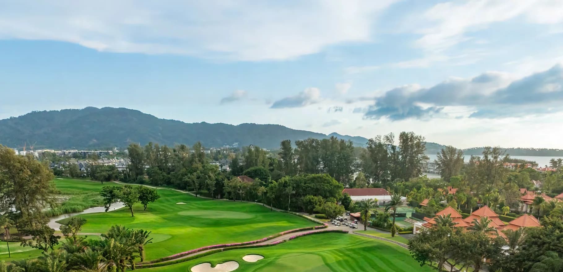 Laguna Golf Phuket: ein Fairway und Grün an der Lagune mit tropischen Bäumen und Hügeln